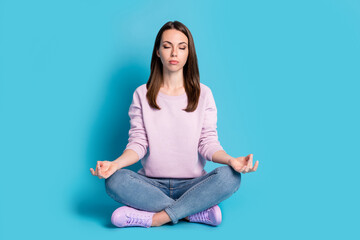 Full length photo of pretty lovely student girl sitting floor crossed legs meditate concentrate find peace motivate wear violet pullover sneakers denim isolated blue color background