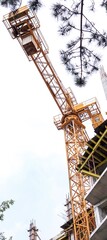 Construction crane stands on the background of the sky. Construction site. Tower crane. Banner.