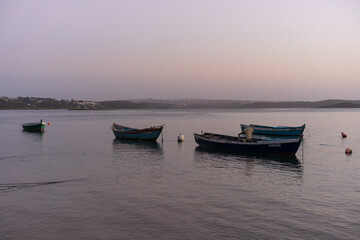 Fototapeta na wymiar Fishing boats on a river sea at sunset in Foz do Arelho, Portugal