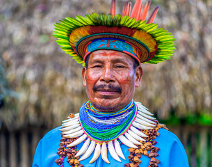 Ecuador. A Shaman from the Siona Community in his traditional costume stands model for a photo....