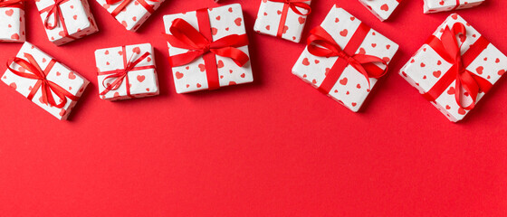 Fototapeta na wymiar Holiday composition of gift boxes with red hearts on colorful background with empty space for your design. Top view of Valentine's Day concept