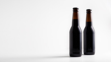 Advertising of delicious beer, full two glass dark beer bottles
