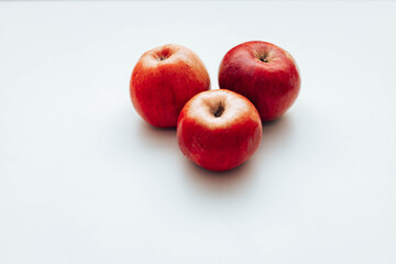 Three red apples on the table. Space for text
