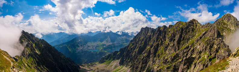 Clouds over the peaks of the High Tatras. View of the eagles trail. Poland. Orla Perć - obrazy, fototapety, plakaty