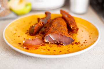 jerky chicken with spices, sliced on a plate.