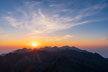 Panorama of early sunrise in the mountains. Summer clear sky with rising sun in the high Tatras in Slovakia. Nice scenery on top in Liptov region.