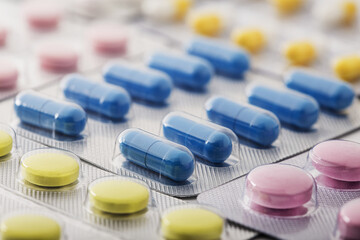 Heap of medical pills in white, blue and other colors. Pills in plastic package. Concept of...