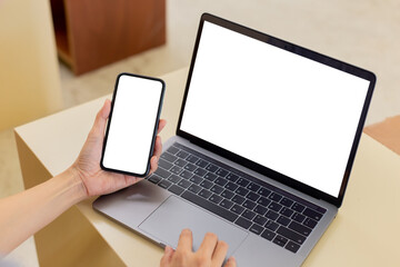 computer,cell phone blank screen mockup.hand woman work using laptop texting mobile. with white background for advertising,contact business search information on desk in cafe.marketing,design