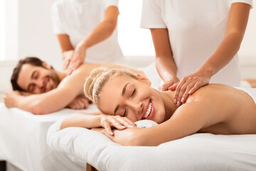 Relaxed Couple Receiving Back Massage Treatment Lying At Spa Resort