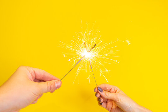 Bengal fire in hand. Hand holds burning sparkler symbol of magic at Christmas. Sparklers in hands, close up