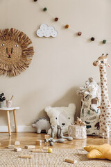 Stylish scandinavian interior of child room with natural toys, hanging decoration, design furniture, plush animals, teddy bears and accessories. Beige walls. Interior design of kid room. Template. © FollowTheFlow