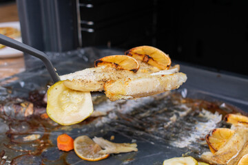 Fillet of sea fish with lemon slices and vegetables. Baking fish in the oven.