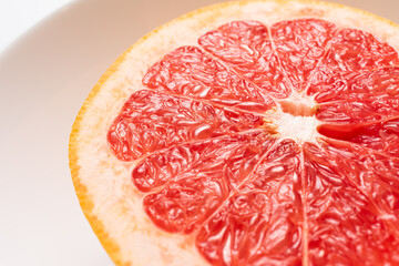 Fresh tasty grapefruit on plate. Half of grapefruit on white background