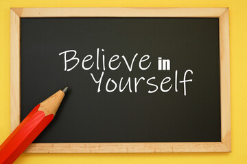 Black chalkboard with a motivational quote and a pencil 