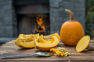 Slicing two sugar pumpkins on a cutting board about to be roasted.   Cooking outside to make this pumpkin puree. - 395013349