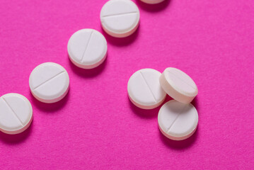 Set of round medical tablet pills on pink background