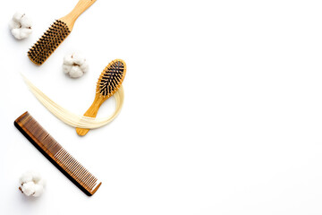 Strand of blond hair wirh hairbrush, flat lay