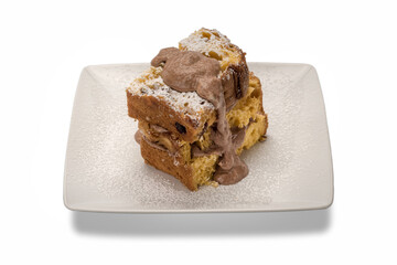 Slices of panettone with caramel cream dulce de lece on the white rectangular plate, typical Italian dessert for Christmas from Milan, isolated on white background