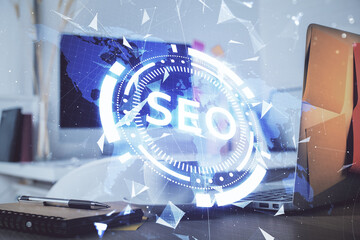 Double exposure of table with computer and seo drawing hologram. Search optimization concept.