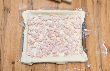 The process of smearing the cake with a brush. The girl greases the cake with a brush. Cooking apple strudel at home in the kitchen. Mom in an apron lubricates the cake. The pie is sent to the oven.