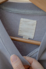 Clothing label on light gray fabric.  Fashion brand name mock up, closeup, top view