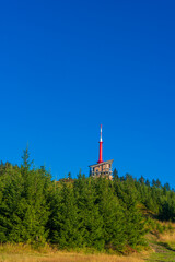Obraz premium Lysa hora, Beskids mountains ( Beskydy ), Czech republic / Czechia, Central Europe - pathway leading to top of the hill. High building of Transmission tower on the peak. Late Summer with dry grass