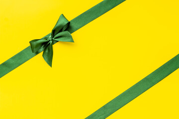 Green ribbon with bow for holiday gift box or greeting card banner. Top view