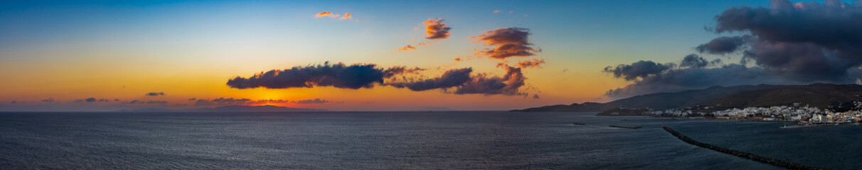 Panorama von Tinos Stadt zum Sonnenuntergang hinter der griechischen Kykladeninsel Syros