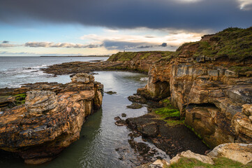 Obraz premium Cliffs and Coves at Rumbling Kern, on the rocky shoreline at Howick on the Northumberland coast, AONB, where there are several sandy coves
