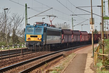 Fototapeta na wymiar Freight train on the rails passing through a station