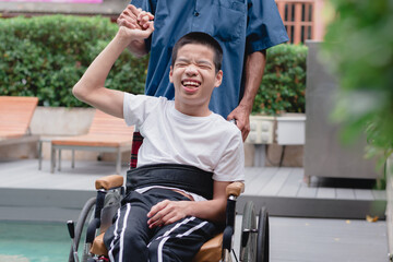 Asian special child on wheelchair and parent with swimming pool background,The boy happiness in...