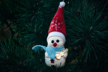 Snowman with a guitar hanging on a pine tree Christmas decoration