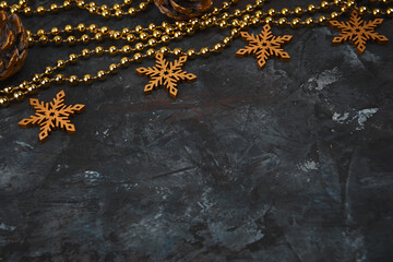 Christmas or New Year dark wooden background, Xmas black board framed with season decorations, space for a text. Christmas Background - Gold Snowflakes On dark background. Golden snowflakes. 
