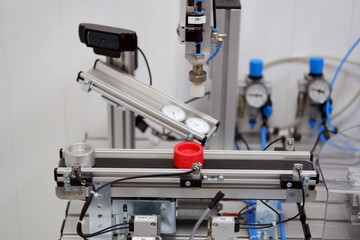 Industry 4.0 concept; artificial intelligence in smart factory. Close-up of product which is classified by sensors on assembly line equipped with sensors and pneumatic pieces of equipment.