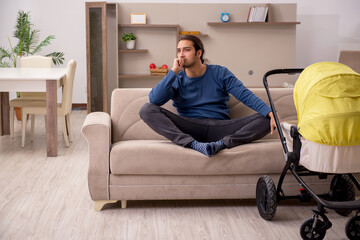 Young male contractor looking after baby at home