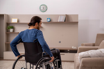 Young man in wheel-chair suffering at home