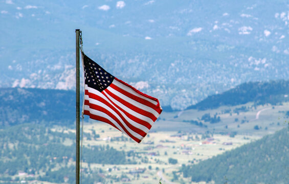 An America Flag Flies Over The Colorado Rocky Mountains.