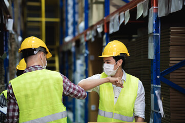 Diverse males warehouse colleague  wear face mask, keeping social distancing and greeting by...