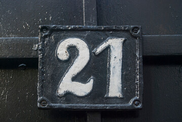 Old retro weathered cast iron plate with number 21 closeup
