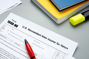  Financial concept meaning Form 1040-NR U.S. Nonresident Alien Income Tax Return with sign on the piece of paper.