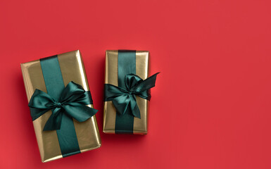 Christmas background with gift boxes with satin ribbons  on red background. Trendy design in color of 2021. Top view with copy space.