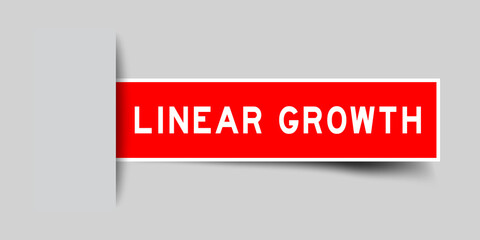 Inserted red color sticker label with word linear growth on gray background