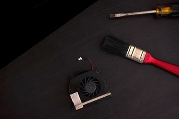 A screwdriver, a cpu fan is placed on the desk.