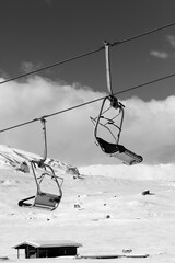 Snowy slope, ski-lift and sky with clouds at sunny winter day