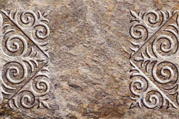 Ornamental print on the stone surface. Vintage ornament on the stone. Close-up seamless texture. Stone texture. Pattern on the stone. Embossed pattern. Wallpaper.