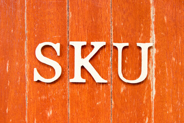 Alphabet letter in word SKU (abbreviation of stock keeping unit) on old red color wood plate background