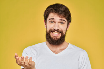 Bearded man in white t-shirt emotions close-up fun yellow background
