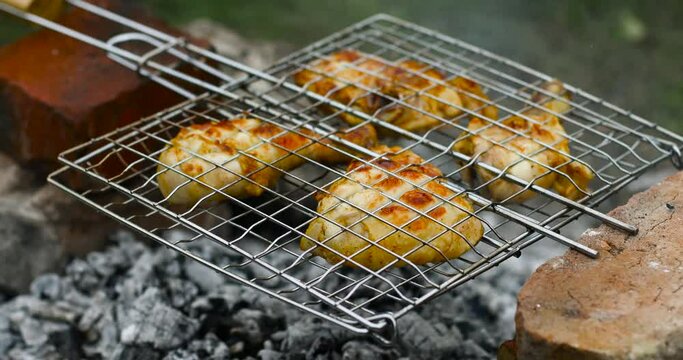 Fragrant chicken legs on an open fire. Golden crust on chicken meat