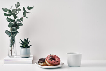 Mug and donuts cakes on a white background. Confectionery, coffee shop. Copy space, mock up.