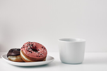 Mug and donuts cakes on a white background. Confectionery, coffee shop. Copy space, mock up.